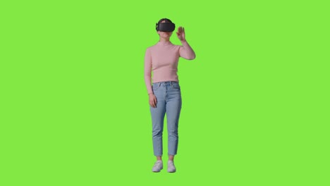 Ganzkörperaufnahme-Einer-Frau,-Die-Ein-Virtual-Reality-Headset-Trägt-Und-Vor-Einem-Greenscreen-Studiohintergrund-Interagiert-1
